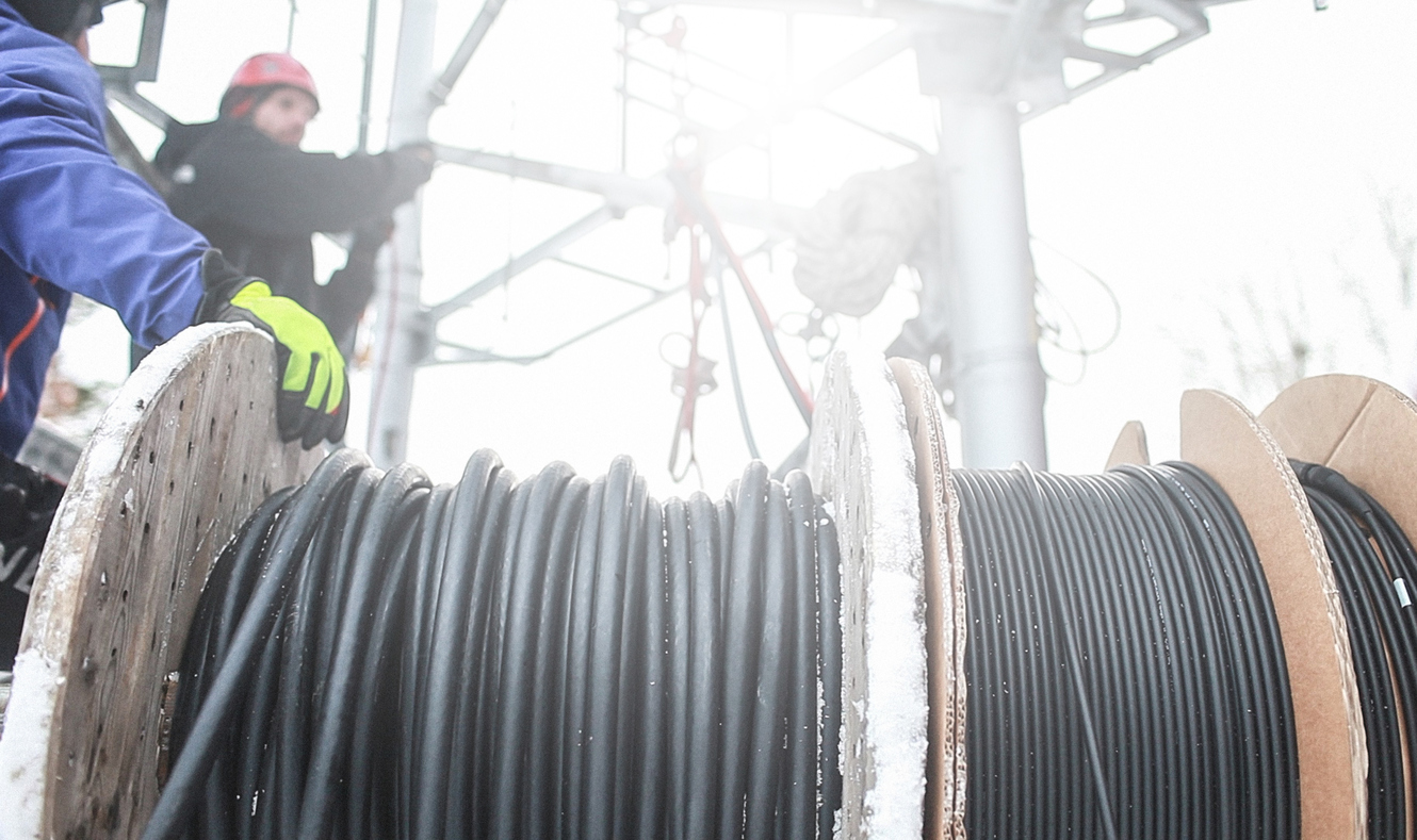 Electrical cable on wooden reels being pulled at a jobsite, demonstrating safe handling and efficient wire pulling systems.